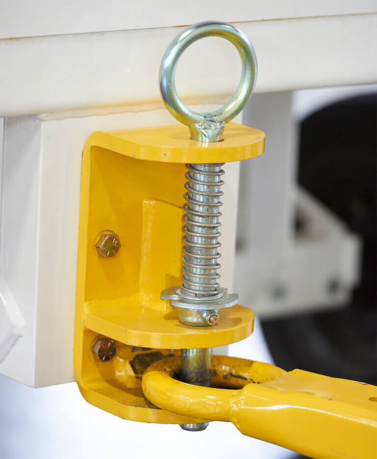 Yellow spring-loaded tow hitch assembly featuring metal eye bolt, compression spring, and mounting bracket attached to white cart frame.