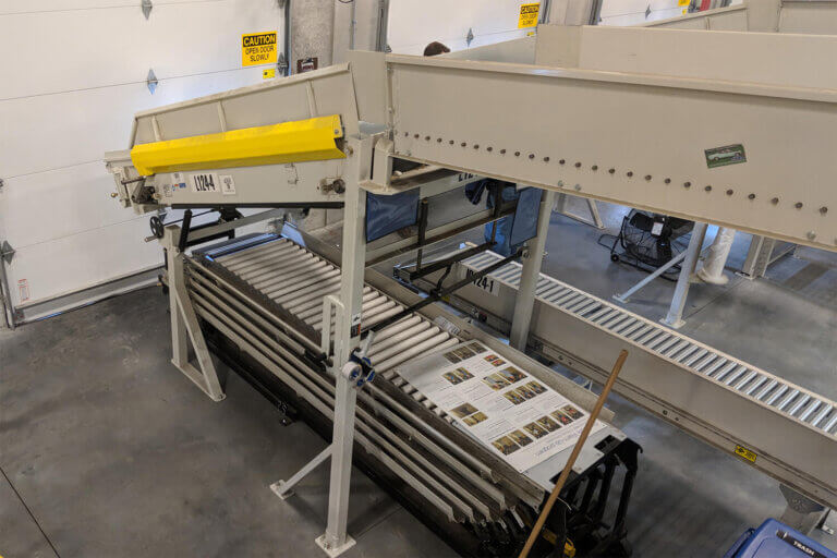 Warehouse loading dock with gravity roller conveyor system.