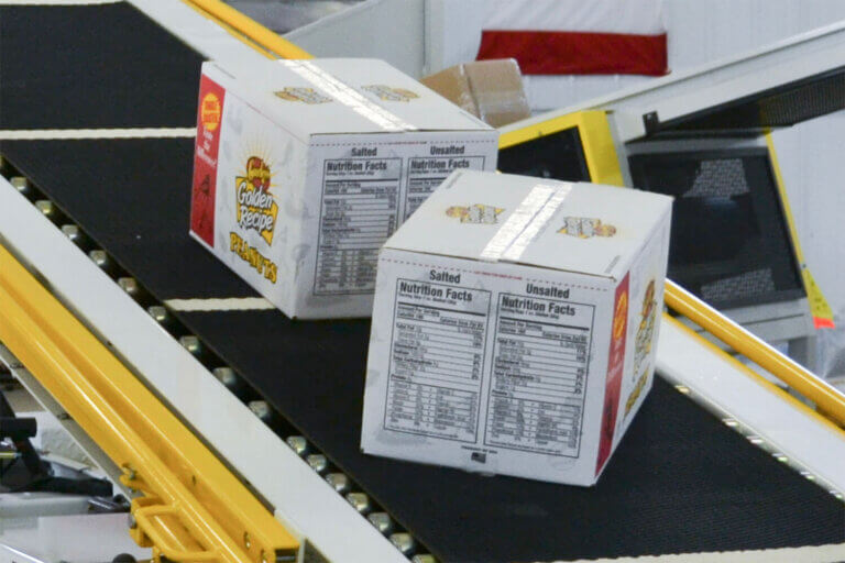 White boxes moving along a black conveyor belt.