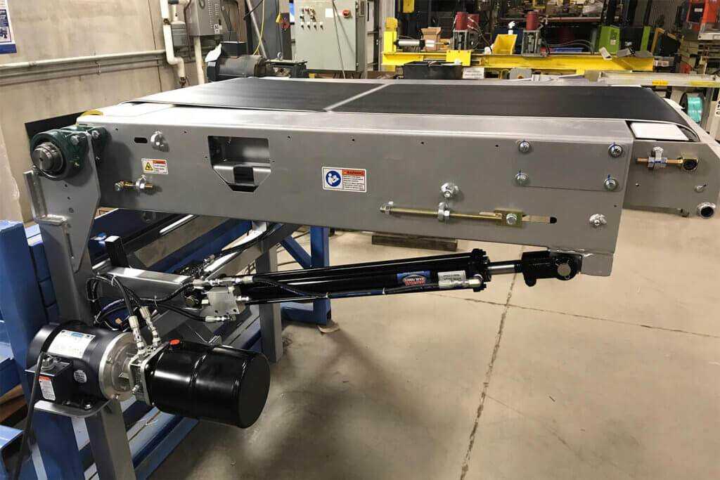 Industrial conveyor belt system with hydraulic components installed in manufacturing facility.