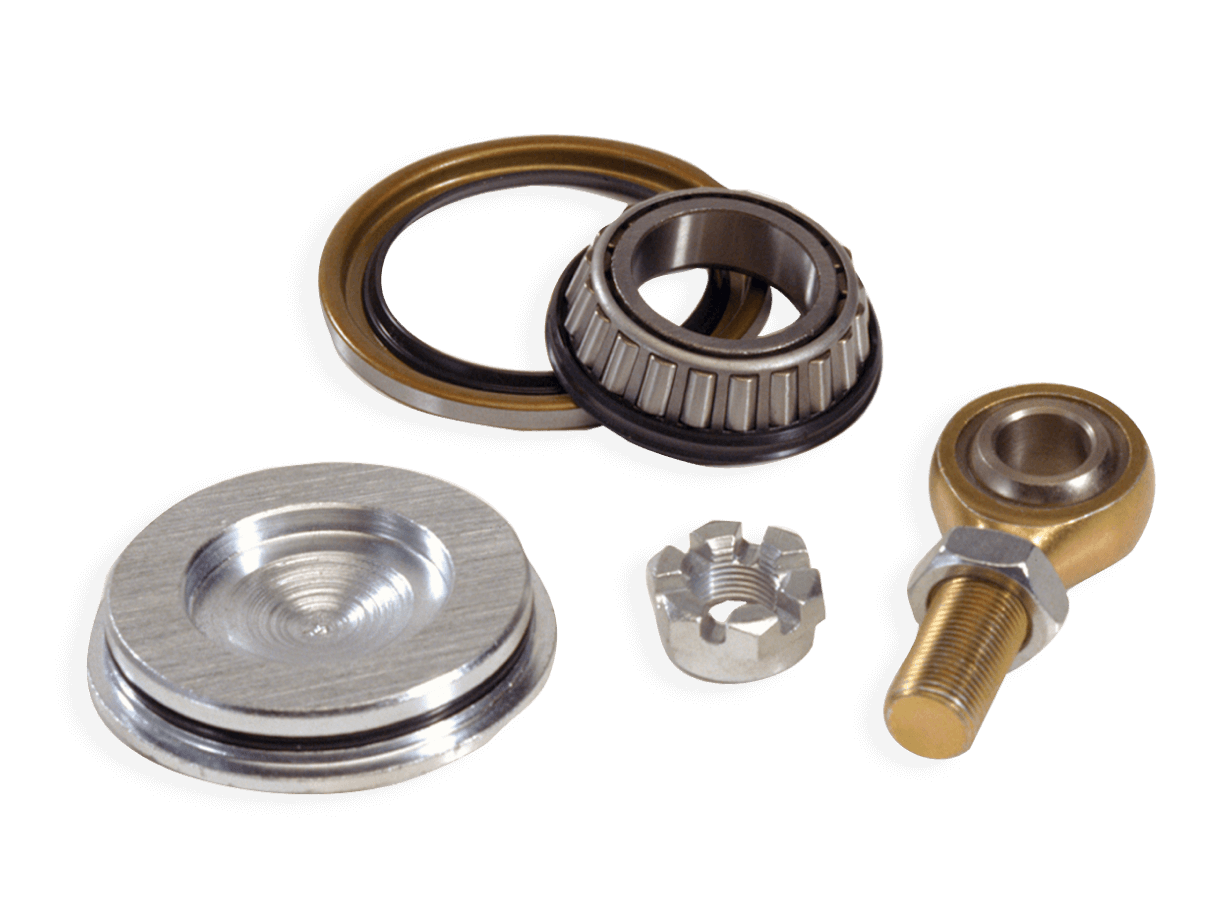 Collection of mechanical bearing components including a tapered roller bearing, seal, washer, castle nut and rod end arranged on white background.